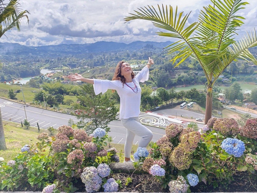 Nicia López disfrutando de un viaje, con los brazos abiertos ante un paisaje natural